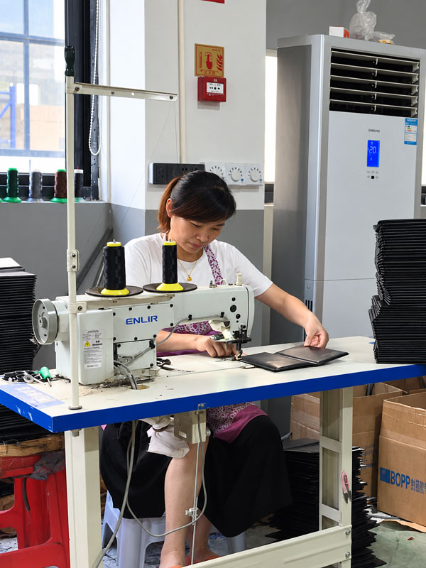 Skilled worker sewing menu covers in Menunique in-house operation